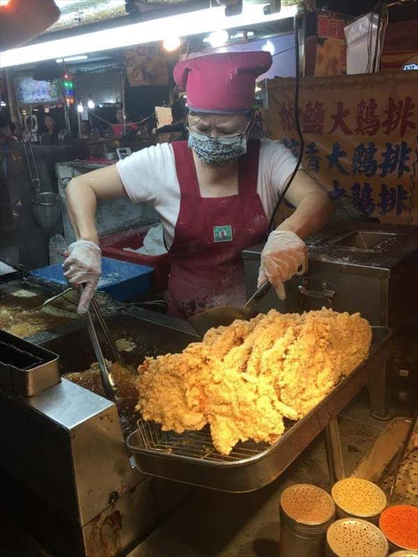 夜市　フライドチキンを揚げる女性